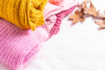 Colorful knitted sweaters on white background 