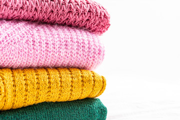 Colorful knitted sweaters on white background 