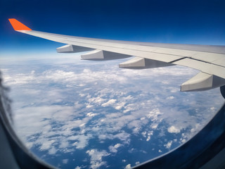 During the morning journey view of wing of an airplane from window seat overlooking clouds and sky 