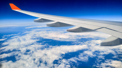 During the morning journey view of wing of an airplane from window seat overlooking clouds and sky 