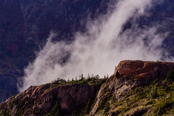 Landscape view of a mountain peak and ascending clouds behind it
