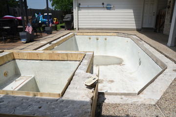 Empty swimming pool under remodel with wooden forms for new tile and coping and concrete