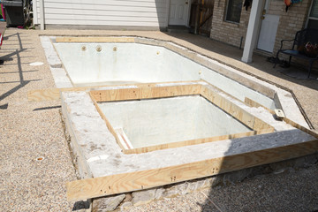 Empty swimming pool under remodel with wooden forms for new tile and coping and concrete
