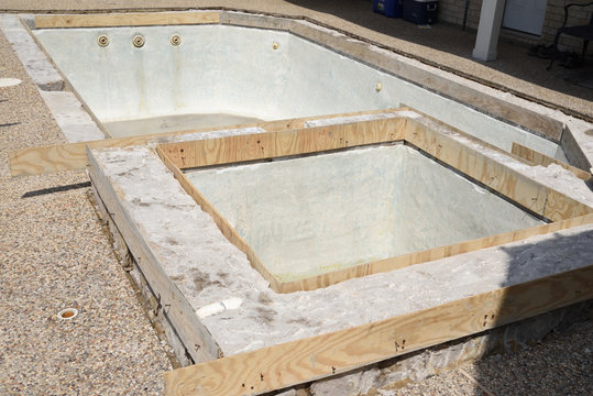 Empty swimming pool under remodel with wooden forms for new tile and coping and concrete