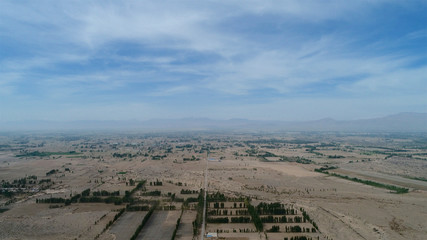 Aerial view of poor small village with school in the middle of dry farm land during hot summer season , Gansu, China