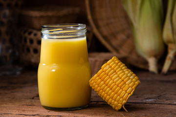 Fresh sweet corn juice (corn milk) and corn on wood background