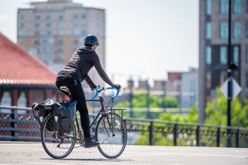 Cyclist girl prefers bicycles as an ecological transportation and rides bicycle down urban city...