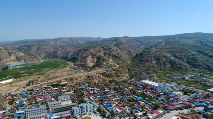 Fototapeta na wymiar Aerial view of small poor village next the dry mountain in Gansu, China