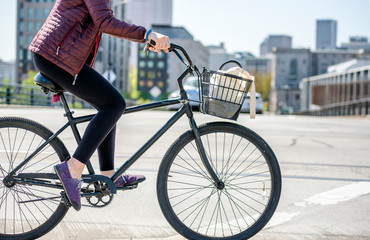 Cyclist girl prefers bicycles as an ecological transportation and rides bicycle down urban city street