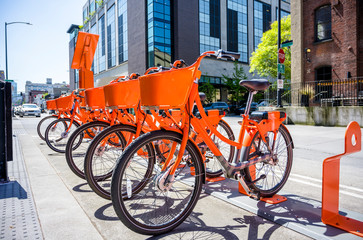 Public rental of orange bicycles with basket for cycling enthusiasts around the city