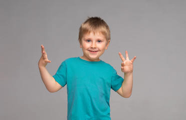 Portrait of happy smiling boy in blue t-shirt. Attractive kid in studio.