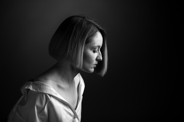 Fototapeta premium Dramatic black and white portrait of a beautiful woman on a dark background
