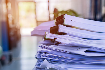 Stacks of piles unfinished papers documents files in accounting business report with black clips...