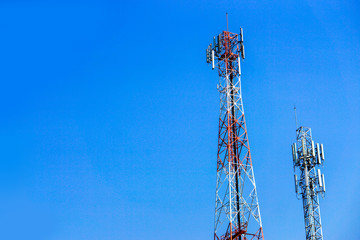 Closeup and crop communication tower with antennas on the top and bright blue sky background with...