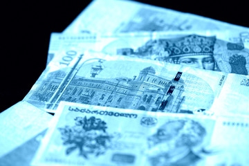 Georgian lari on a dark background close up. Blue color toned