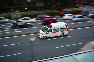 Fototapeta na wymiar ハイアングルで流し撮りした幹線道路を走る日本の救急車