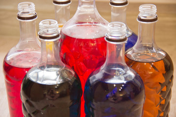 Plastic bottles filled with liquid of different colors.