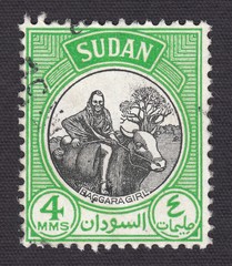 Obraz premium The girl of the indigenous people of Baggara riding a bull, stamp Sudan 1951