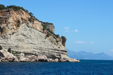 Fototapeta na wymiar Rocks near the coast of the Mediterranean sea on a background of mountains in Turkey