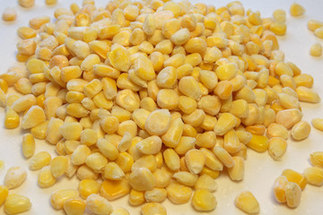 Sweet frozen corn kernels on white background.