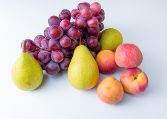 Different fresh fruits. A bunch of grapes, pears, nectarines. soft textures of fruits on a white background