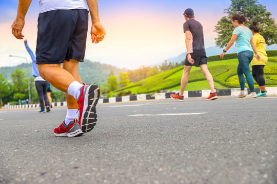 Close Up Senior Man Legs With Group People Walking In The Park