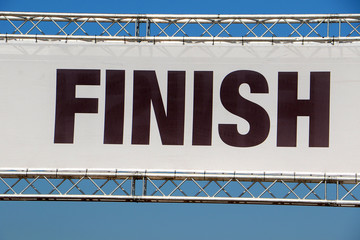 Finish line banner across a clear blue sky