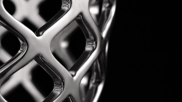 Smooth circular motion of a chrome surface, black background, abstraction
