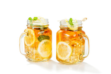 Iced tea with lemon slices and mint isolated on white background