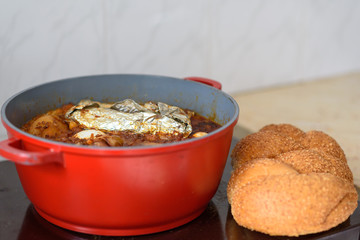 Hot plate for the Sabbath, a pot of spicy meat cooked with potatoes, barleys, wheat and eggs. Pot of cholent Hamin in hebrew, challah-special bread in Jewish cuisine. Traditional food Jewish Shabbat.