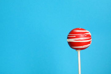 Bright delicious cake pop on color background. Space for text