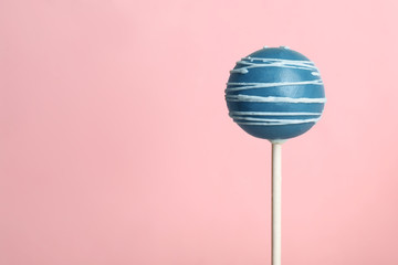 Bright delicious cake pop on color background. Space for text