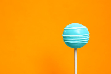 Bright delicious cake pop on color background. Space for text