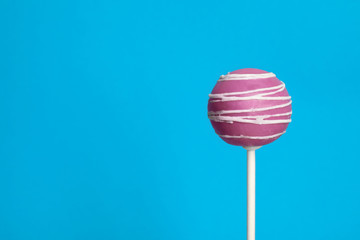 Bright delicious cake pop on color background. Space for text