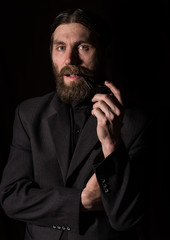 vintage handsome bearded man with a smoking pipe on a dark background