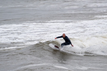 Male surfing  in light rain