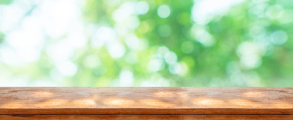 wood table top in front of natural blur bokeh background and copy space. display or montage products banner size.