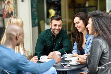 Multiracial group of five friends having a coffee together
