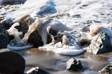 Fototapeta premium Ocean water cresting over a rock