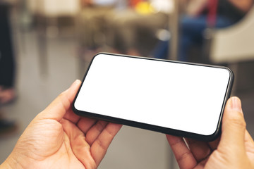 Mockup image of woman's hands holding black mobile phone with blank screen in subway