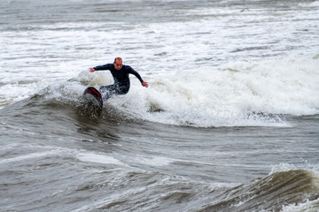 middle-aged surfer rides the waves