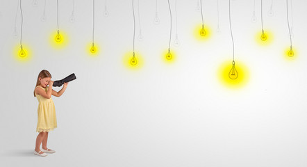 Cute little girl looking through spyglass to lighting bulbs
