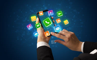 Female hand using smartphone with 3D shiny starlike application icons around
