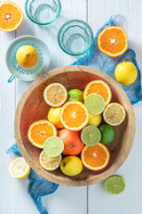 Top view of oranges, limes and lemons on wooden table