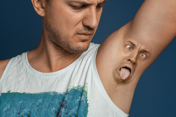 Smelly armpits in men. Concept of twisted panting face from bad smell. - obrazy, fototapety, plakaty