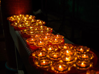 SINGAPORE, 18 MAY 2019 -A row of Buddhist oil lamps in a temple at Vesak Day celebrations. giving off a calm, serene, spritual warm light