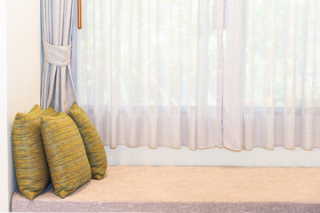 Beautiful comfortable pillow on sofa decoration with curtain