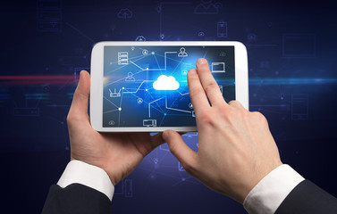 Obraz premium First person view of a hand using tablet with cloud office concept 