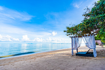 Empty bed chair and lounge on the tropical beach sea ocean with white cloud on blue sky