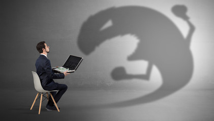 Young businessman staying and  negotiate with a monster shadow
